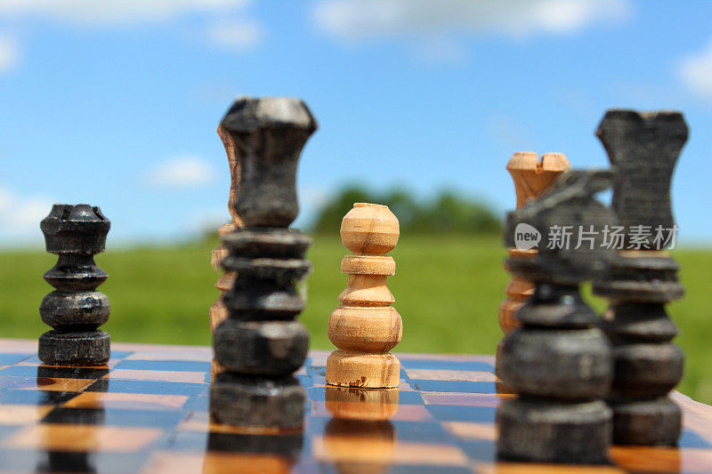 棋盘游戏/木制棋子对抗天空的图像，棋盘游戏